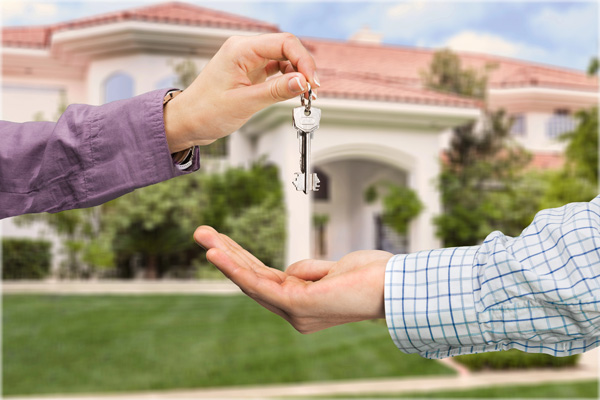 real-estate-agent-in-front-of-house-giving-key